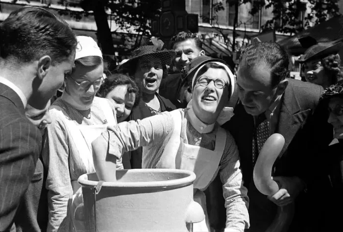 Framed Print : A nurse is watched as she dunks her hand into a bucket at Barts Fair April 1938