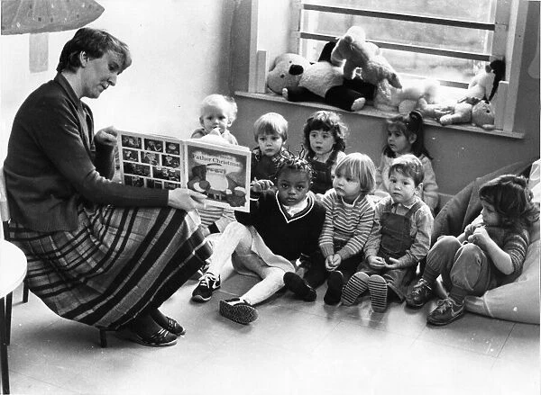 A nursery class listen to a story read by the teacher