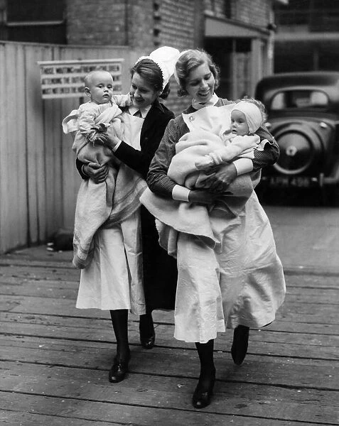 Nurses help evacuate two babies from Great Ormond Street Hospital Circa 1940