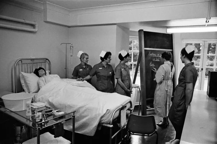 Framed Print : Nurses receiving instruction from Miss V Thomas (in surgical gown) on patient care Framed Print : Nurses receiving instruction from Miss V Thomas (in surgical gown) on patient care