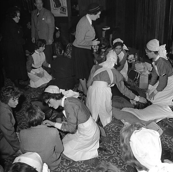 Nurses tend to fans during a performance by British pop group The Beatles at the Ritz