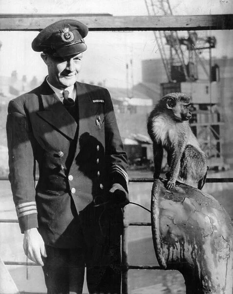 A officer and his mascot. On board a ship. The caption mentions the name Miss