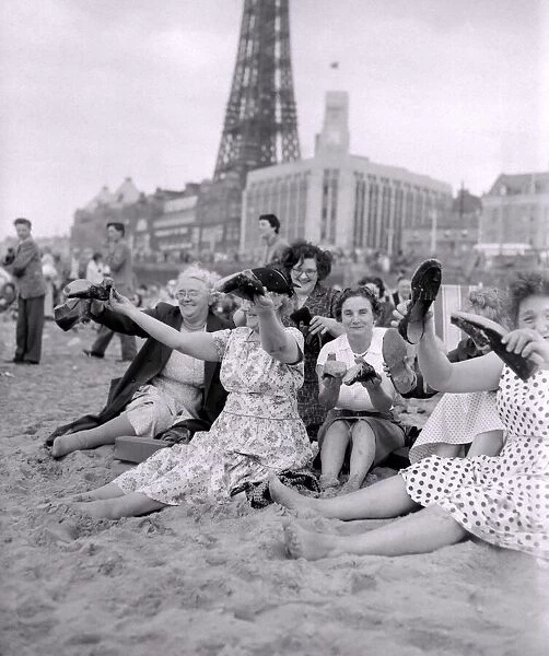 The old folks go young for a day. Women sitting on Blackpool beach emptying