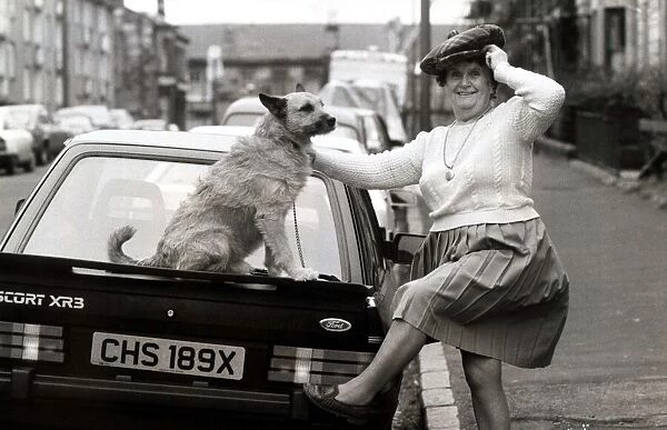 Old lady with her dog on a car circa 1990