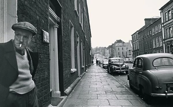An old man standing in a doorway, smoking Street scene Georgian buildings