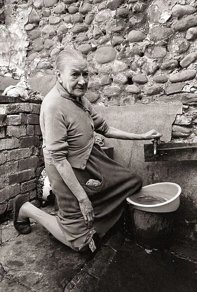 Old Mary Wallace washes her dishes outside in hubert Street in Newtown cardiff