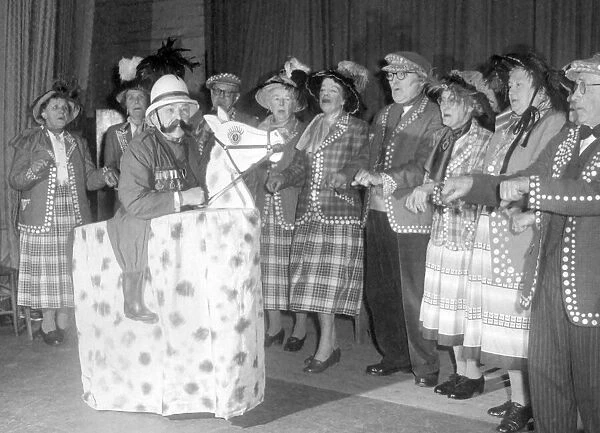 Old people dressed as Pearly Kings and Queens performing on stage during a concert
