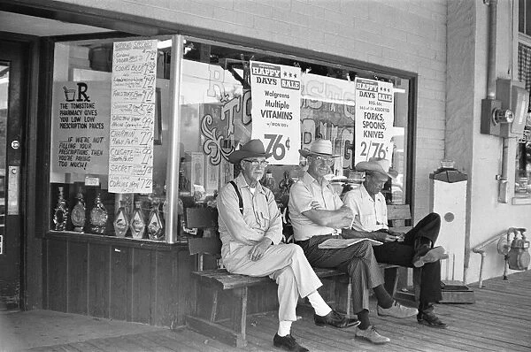 Three old timers sit outside the Tombstone Drug store close to the site of the famous