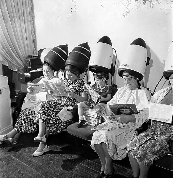 Old women sitting with their heads under a dryer as they get their hair styled