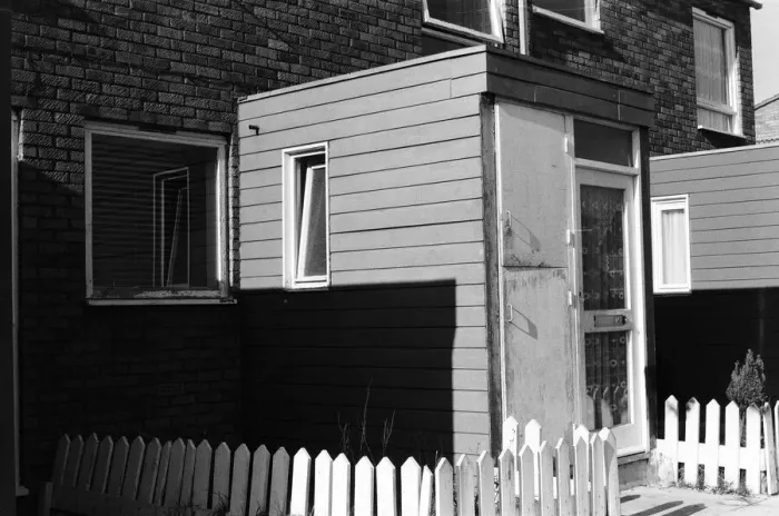 Framed Print : Painted council houses and the unpainted ones - part of a battle of home buying at a Framed Print : Painted council houses and the unpainted ones - part of a battle of home buying at a