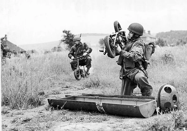 Paratrooper assembles his folding motor scooter - a. k. a