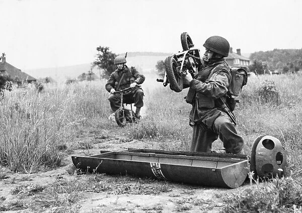 A paratrooper lifts a folding motor scooter from its parachute container
