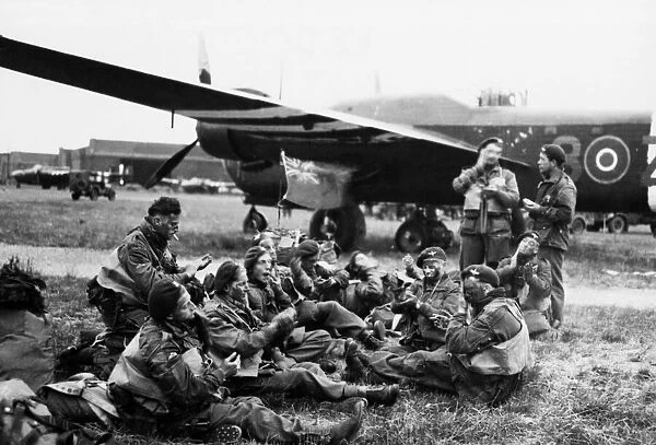 Paratroops sitting with their kits ready for emplaning, they have a Union Jack which will
