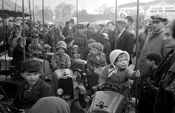 Parents watch as their children ride on a merry-go-round at Blackheath Fair April