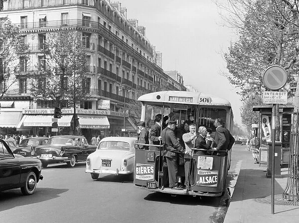 Paris commuters standing on the tail platform of a bus. May 1960