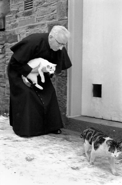 The parish priest seen here gathering up his pet cats February 1970 70-1627-001