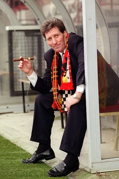 Partick Thistle football manager John Lambie smoking a cigar as he sits in the dugout