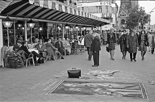 Passers by stop and admire the work of street artists, who uses the pavements of