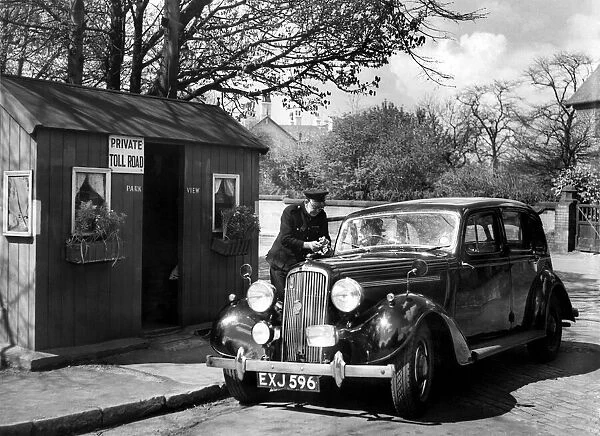 A passing motorist pays up at one of the toll boxes in Victoria Park, Manchester, to-day