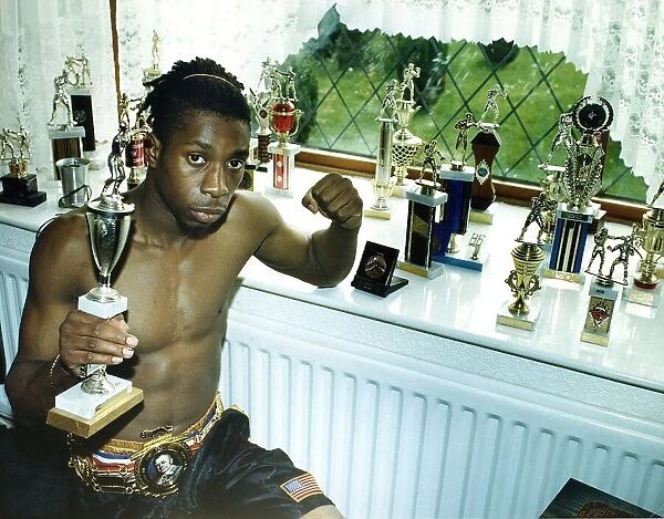 Pat Barrett the professional Welter weight boxer sits alongside his trophies