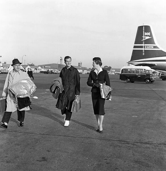 Pat Boone arriving at London Airport. BOAC air receptionist Priscilla walks with him