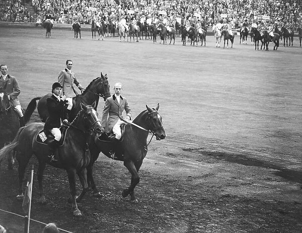 Pat Smythe and two other members of the British Team ride past the Royal box at