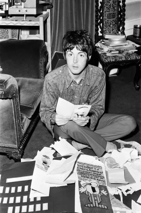 Framed Print : Paul McCartney of The Beatles sitting on the floor cross legged as he opens up birthday