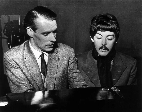 Paul McCartney playing the piano with producer George Martin, circa November 1966