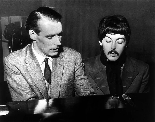 Paul McCartney playing the piano with producer George Martin, circa November 1966