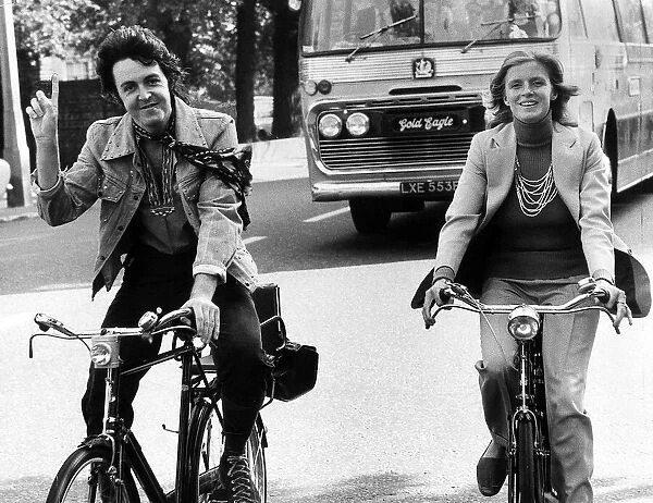 Paul McCartney former singer with The Beatles with wife Linda out riding bicycles