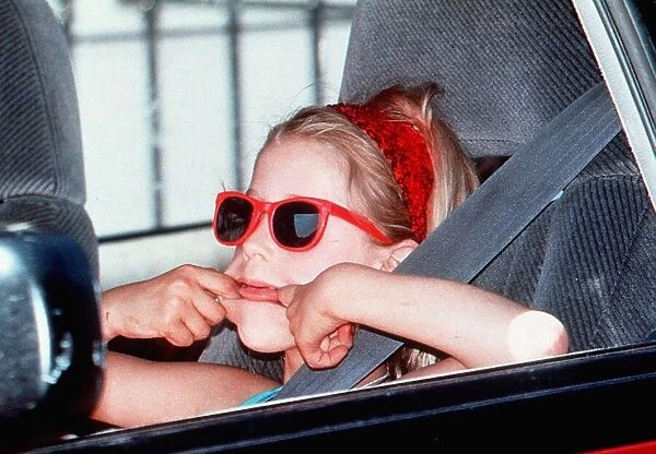 Paula Yates daughter-Peaches in red sunglasses pulling face in back of car on way to