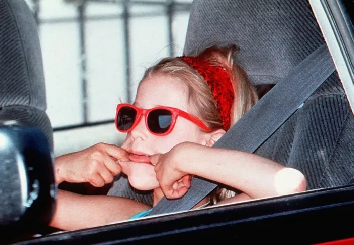 Framed Print : Paula Yates daughter-Peaches in red sunglasses pulling face in back of car on way to