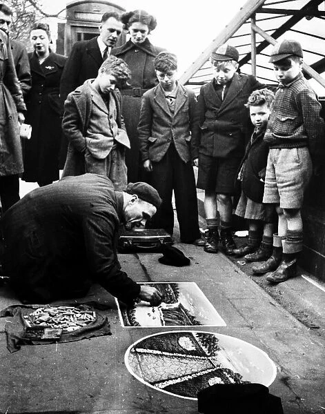 Pavement Artist at work along the Embankment, London. 1951