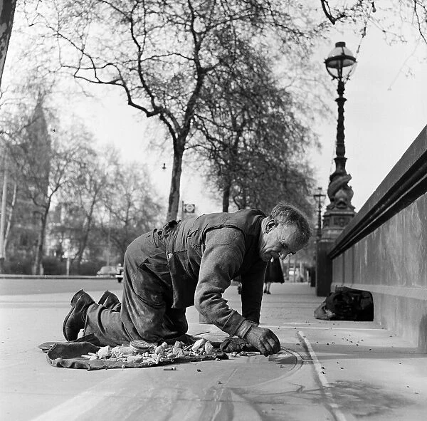 Pavement Artist at work on the Embankment, London. Circa 1945