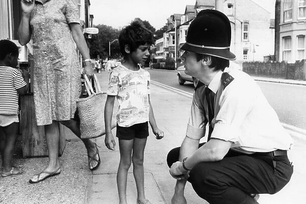 PC Nigel Barber speaks with a young boy, during patrol pod the streets of Cambridge