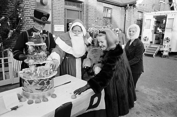 PDSA animal Christmas party. Pictured, Millicent Martin cuts the huge Christmas cake