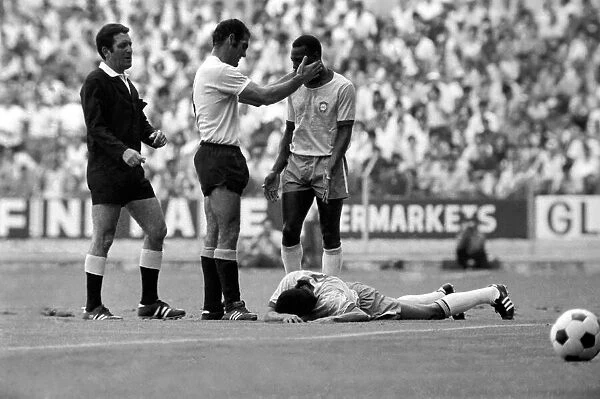 Pele is calmed down by a Uruguain player whilst a felled Jairzinho lies on the ground