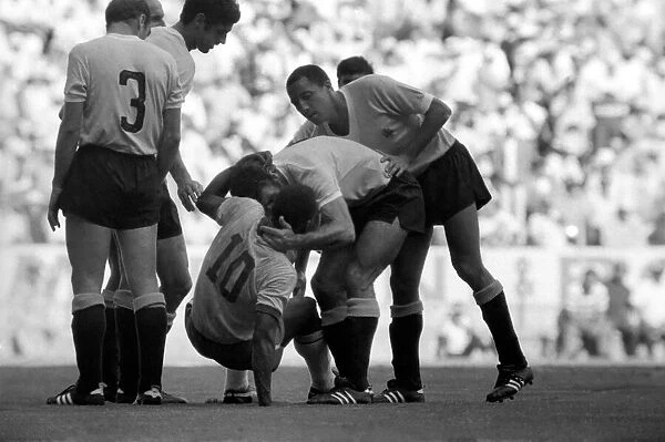 Pele is helped to his feet by a Uruguain player. Brazil v. Uruguay: World Cup Semi-Final