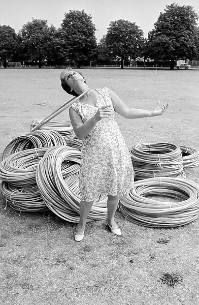 Pensioner playing with Hula Hoops in a Twickenham park. August 1976 P76 734
