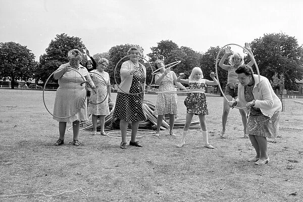 Pensioners playing with Hula Hoops in a Twickenham park