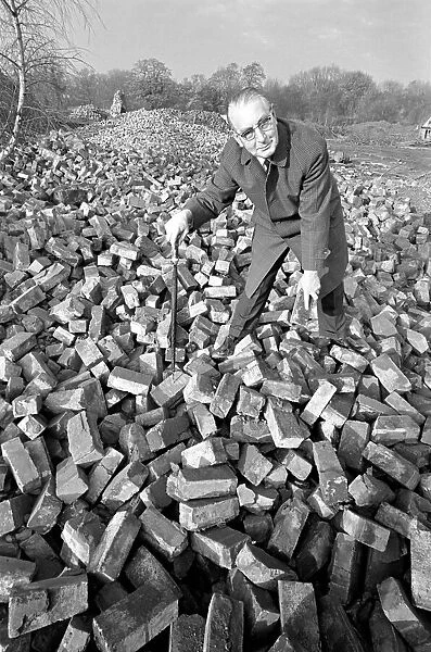 People - elderly. An old man searching through a pile of bricks. December 1969 Z11973