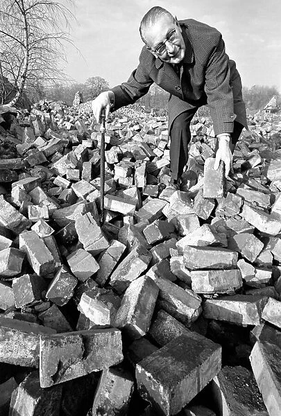 People - elderly. An old man searching through a pile of bricks. December 1969 Z11973-001