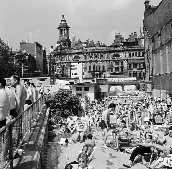 People enjoying the warm weather at Endell Street open air baths, London. 5th August 1954