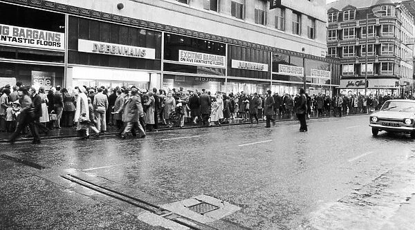People queue around the Debenhams building in Market Street