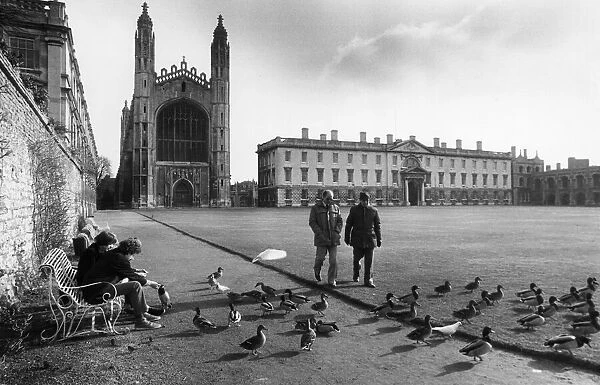 People talking a walk on the lawn outside Kings College in central Cambridge