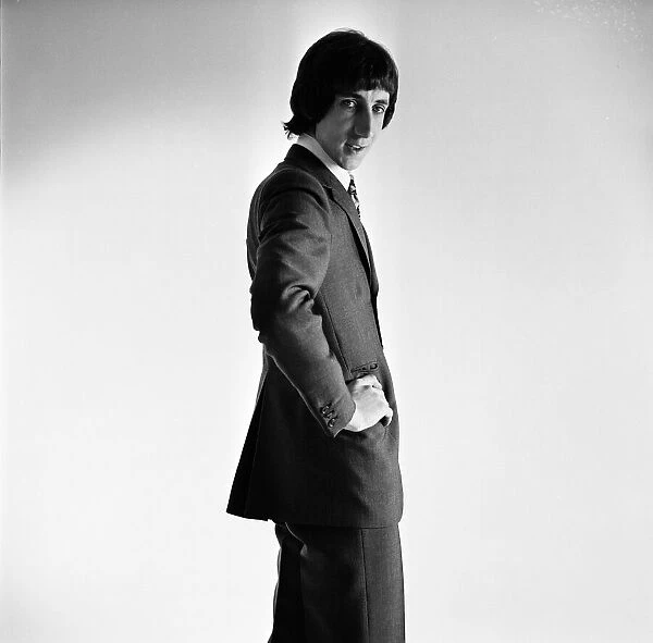 Pete Townshend of British rock group The Who, poses in the studio wearing suit and tie