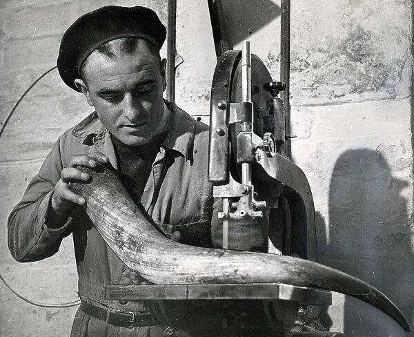 Peter Curran working on a horn at a horn factory April 1953