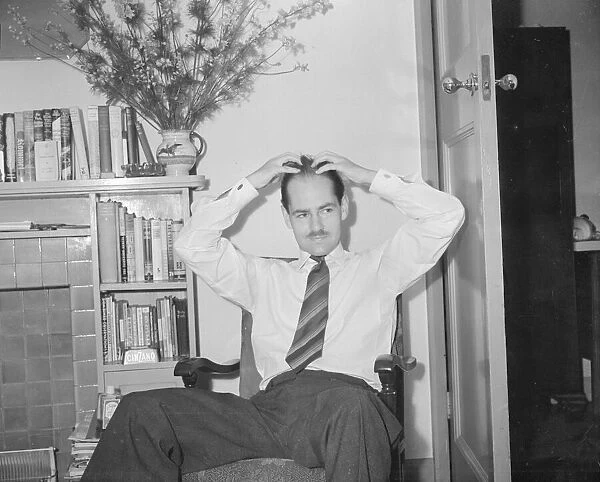 Peter Haigh 28 youngest of the BBC TV announcers, seen here at home applying hair