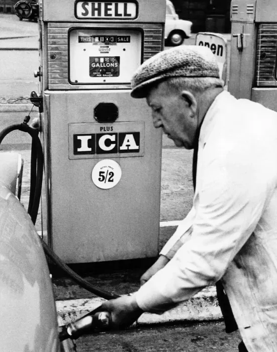 Framed Print : A Petrol pump attendant filling up a cars tank with fuel at a service station
