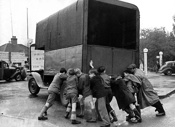 Petrol Shortages 1953. Boys pushing a lorry which has run out of fuel
